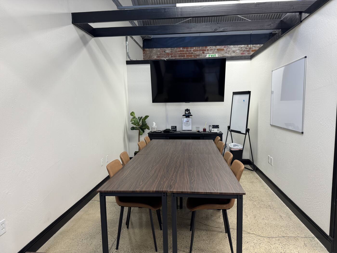 Valley Roots Realty private conference room — wooden table, TV, and whiteboard