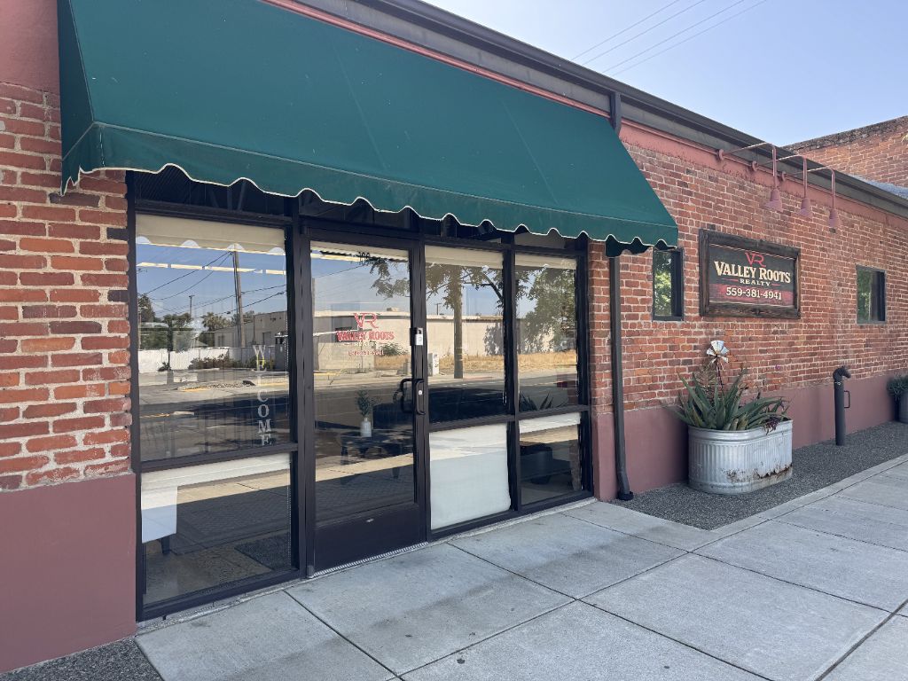 Valley Roots Realty office exterior — brick building with green awning on S Douty Street, Hanford